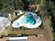 Aerial view of a community pool, jacuzzi, and cabana surrounded by trees and lush landscaping at 1808 Cypress Trace Dr # 1808, Safety Harbor, FL 34695