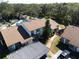 Aerial view showcasing the building, carport, a community pool, and surrounding lush greenery at 1808 Cypress Trace Dr # 1808, Safety Harbor, FL 34695