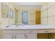 Neutral bathroom vanity with a white countertop and an expansive mirror reflecting an adjacent commode and shower at 1808 Cypress Trace Dr # 1808, Safety Harbor, FL 34695