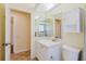 Bathroom with a tiled floor, white cabinets, and an expansive mirror reflecting the walk-in shower at 1808 Cypress Trace Dr # 1808, Safety Harbor, FL 34695
