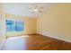 Bedroom with hardwood floors and a large window overlooking the greenery outside and a ceiling fan at 1808 Cypress Trace Dr # 1808, Safety Harbor, FL 34695
