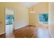 Bright and airy dining room with hardwood floors, a modern chandelier, and a window overlooking the greenery at 1808 Cypress Trace Dr # 1808, Safety Harbor, FL 34695