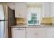 Bright kitchen with white cabinets, stainless steel appliances, and a window overlooking a serene view at 1808 Cypress Trace Dr # 1808, Safety Harbor, FL 34695