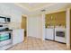 Well-lit kitchen features modern appliances and closet with laundry machines at 1808 Cypress Trace Dr # 1808, Safety Harbor, FL 34695