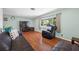 Bright living room with large window, hardwood floors, a leather recliner, and a large sectional at 1900 60Th N Way, St Petersburg, FL 33710