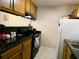 Galley kitchen with dark countertops, wood cabinets, and white appliances at 2302 Maki Rd # 62, Plant City, FL 33563
