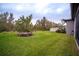 Large backyard with grassy area and mature landscaping at 7465 Yale Harbor Dr, Wesley Chapel, FL 33545