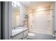 Clean bathroom with white bathtub, granite countertop, and shelves at 7465 Yale Harbor Dr, Wesley Chapel, FL 33545