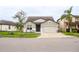 Two-story house with gray siding, two-car garage, and well-manicured lawn at 7465 Yale Harbor Dr, Wesley Chapel, FL 33545