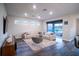 Living room with sectional sofa, sliding doors to backyard, hardwood floor at 7465 Yale Harbor Dr, Wesley Chapel, FL 33545