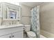 Bathroom with white vanity, shower/tub combo, and blue shower curtain at 1000 Gulf Blvd # 302, Indian Rocks Beach, FL 33785