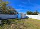 A fenced backyard featuring a well-maintained lawn and a charming blue shed, perfect for storage at 10232 Oakhurst Rd, Largo, FL 33774