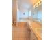 Bright bathroom boasts a large soaking tub with tile surround, double vanity, and a tile floor at 10232 Oakhurst Rd, Largo, FL 33774