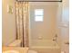Full bathroom with a shower-tub combo and floral shower curtain plus small window at 10232 Oakhurst Rd, Largo, FL 33774