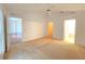 Spacious bedroom featuring an open door and a ceiling fan that complements the neutral carpeting at 10232 Oakhurst Rd, Largo, FL 33774