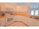 Bright kitchen featuring tile flooring, white appliances, and plenty of cabinet space at 10232 Oakhurst Rd, Largo, FL 33774