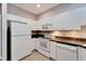 Efficient kitchen layout with white appliances, offering a practical and functional space for meal preparation and storage at 1050 Starkey Rd # 704, Largo, FL 33771