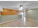 Loft room with orange accent wall and wooden floors and a sliding door to an outdoor balcony at 1050 Starkey Rd # 704, Largo, FL 33771