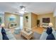 Comfortable living room with sofas, coffee table, and entertainment center, complemented by a ceiling fan at 1050 Starkey Rd # 704, Largo, FL 33771
