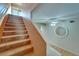 Carpeted staircase with bright lighting, ceiling fan, and entry mirror leading to the upper level at 1050 Starkey Rd # 704, Largo, FL 33771
