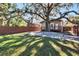 Large backyard with spacious patio, wooden fence, and mature oak tree providing shade at 1100 E Louisiana Ave, Tampa, FL 33603