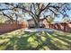 Large backyard with a patio, wooden fence, and a large oak tree at 1100 E Louisiana Ave, Tampa, FL 33603