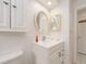 White bathroom with a vanity and oval mirror at 14181 89Th Ave, Seminole, FL 33776