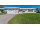 White house with red accents, attached garage, and well-manicured lawn at 14181 89Th Ave, Seminole, FL 33776