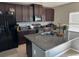 Modern kitchen with dark wood cabinets, granite countertops, and stainless steel appliances at 14207 Alistar Manor Dr, Wimauma, FL 33598