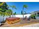 Backyard deck featuring a hot tub and lounge chairs, surrounded by lush landscaping and palm trees at 220 45Th Ave, St Pete Beach, FL 33706