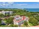 Aerial view of condo complex with water views and lush green landscape in the background at 2650 Pearce Dr # 403, Clearwater, FL 33764