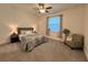 Main bedroom with a gray upholstered bed, nightstands, and a comfortable armchair at 3208 Deleuil Ave, Tampa, FL 33610