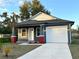 Newly constructed home with gray siding, white garage door, and red brick accents at 3208 Deleuil Ave, Tampa, FL 33610