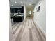 Long hallway view of kitchen and living room with luxury vinyl plank flooring at 3208 Deleuil Ave, Tampa, FL 33610