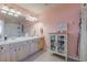 Bathroom with double vanity, light wood cabinets, and a large mirror at 4904 Barnstead Dr, Riverview, FL 33578