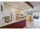 Open kitchen with light wood cabinets, white appliances, and a view into the living room at 4904 Barnstead Dr, Riverview, FL 33578