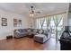 Spacious living room featuring a sectional sofa and wood-look floors, with access to a patio overlooking a lake at 4904 Barnstead Dr, Riverview, FL 33578