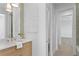 Bathroom featuring modern vanity, white countertop, decorative mirror, creating a bright and inviting space at 6189 Leeland S St, St Petersburg, FL 33715