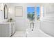 Relaxing bathroom with a standalone tub, marble floors, and natural light from the window at 6189 Leeland S St, St Petersburg, FL 33715
