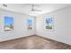 Bright bedroom featuring hardwood floors and three windows offering abundant natural light and neighborhood views at 6189 Leeland S St, St Petersburg, FL 33715