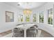 Chic dining room featuring modern chandelier, and large windows with tropical landscaping views at 6189 Leeland S St, St Petersburg, FL 33715