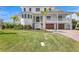 Charming white home featuring lush front yard landscaping and a brick driveway leading to the attached garages at 6189 Leeland S St, St Petersburg, FL 33715