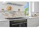 Close-up of the kitchen featuring an industrial-style range, marble backsplash, and stainless steel accents at 6189 Leeland S St, St Petersburg, FL 33715