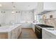 Elegant kitchen showcasing marble counters, island with sink, custom cabinetry, and luxury appliances at 6189 Leeland S St, St Petersburg, FL 33715