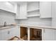 Bright laundry room featuring custom cabinets, shelving, quartz countertop and a convenient sink at 6189 Leeland S St, St Petersburg, FL 33715