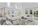 Bright living room featuring hardwood floors, white sofas, and an abundance of natural light at 6189 Leeland S St, St Petersburg, FL 33715