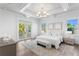 Spacious main bedroom boasts a decorative tray ceiling, french doors, and hardwood floors at 6189 Leeland S St, St Petersburg, FL 33715