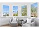 Cozy sitting area with bay windows offering neighborhood views and comfortable armchairs at 6189 Leeland S St, St Petersburg, FL 33715