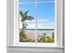 Window view showcasing lush palm trees, a serene body of water, and the bridge in the distance at 6189 Leeland S St, St Petersburg, FL 33715