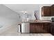 Kitchen with stainless steel dishwasher and dark wood cabinets at 9709 Pembrooke Pines Dr, Sun City Center, FL 33573